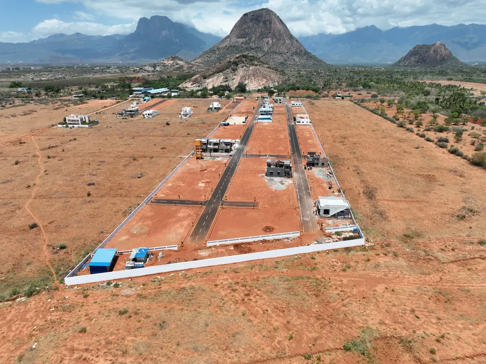 Wider aerial view of the plotted development, showing its boundary against open scrub land